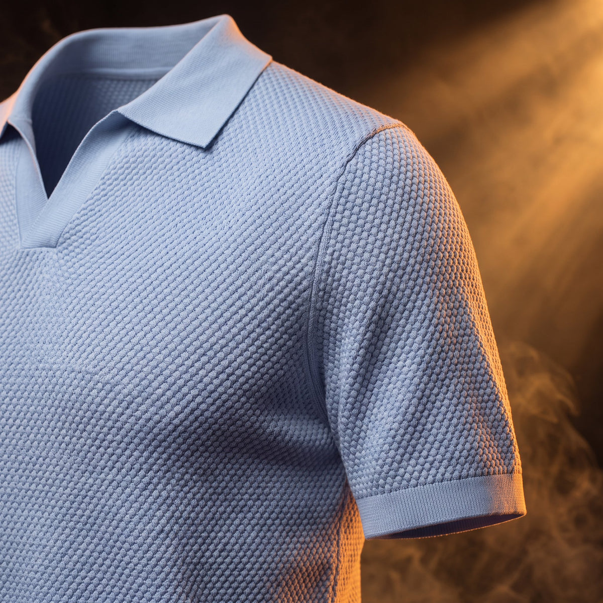 Amedeo knit polo in blue, close-up of the textured knit and sleeve band