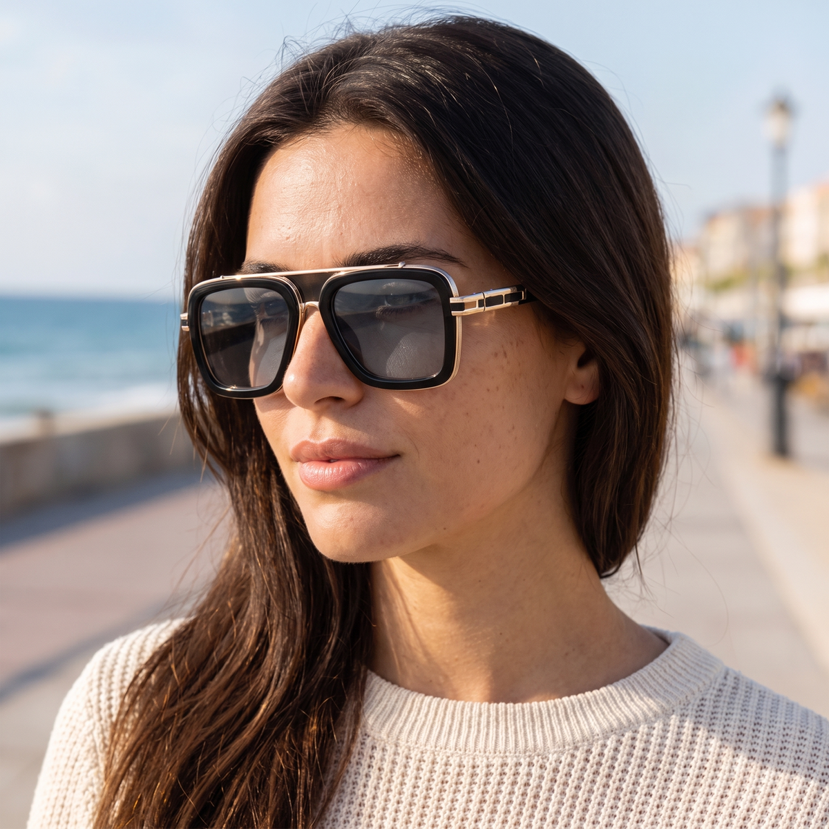 Woman wearing retro square double bridge sunglasses on a seaside promenade